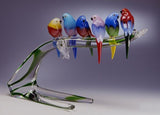 Colourful Murano glass garden birds on a low branch